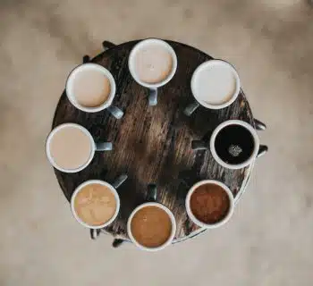 flat lay photography of eight coffee latte in mugs on round table